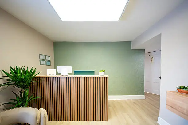 Office reception area with a soft green accent wall and clean interior finishes by a professional painter in Cape Cod, MA.